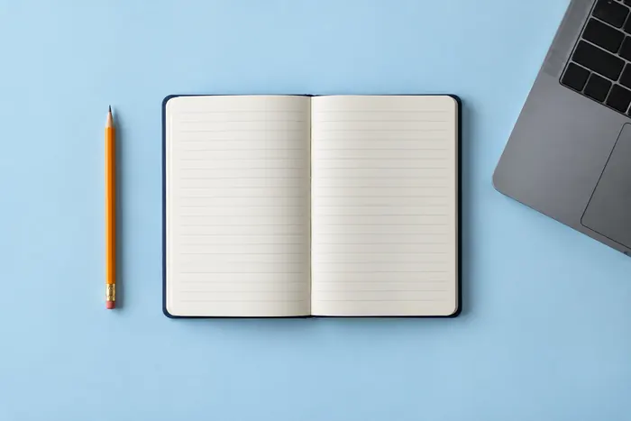 An open notebook, pencil and laptop for independent study